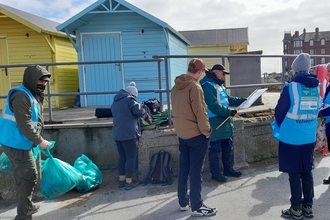 A beach cleaning team of volunteers by the huts in Fleetwood