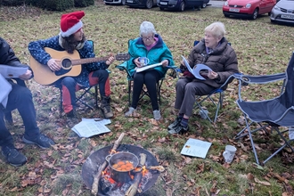 Singing Christmas carols around a firepit.