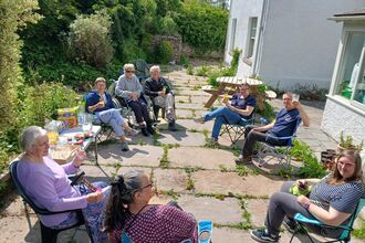A group of people having drinks in the sunshine.