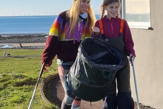 Two people on a beach clean.