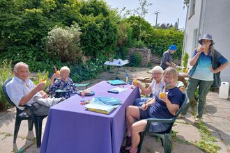 A group of people enjoying drinks in a garden.