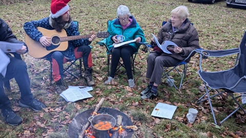 Singing Christmas carols around a firepit.