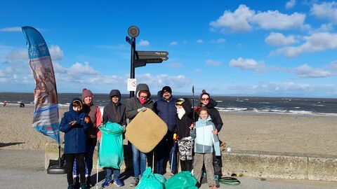 seven people stood with litter picking equipment and full bags next to the beach in Fleetwood