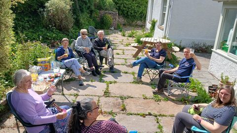 A group of people having drinks in the sunshine.
