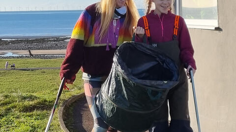 Two people on a beach clean.