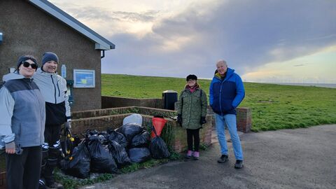 A group of people by litter by a beach.