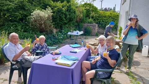 A group of people enjoying drinks in a garden.