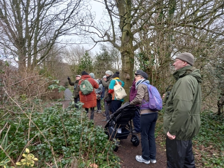 A group of people looking at birds in a park