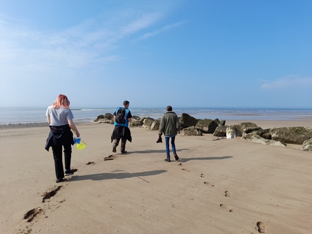 Three people walking on a beach