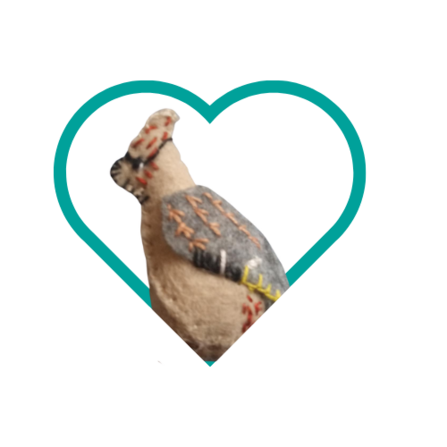 A felt waxwing in a heart frame