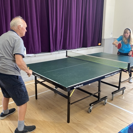 Two people playing table tennis