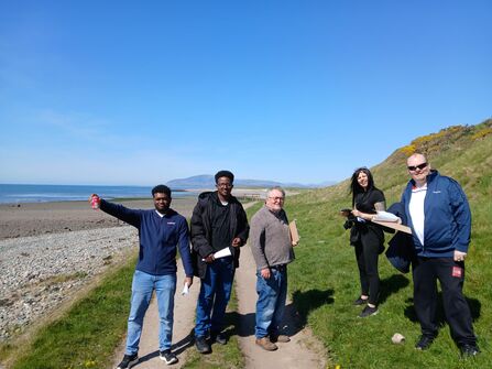 A group of people going for a walk along a coastal path.